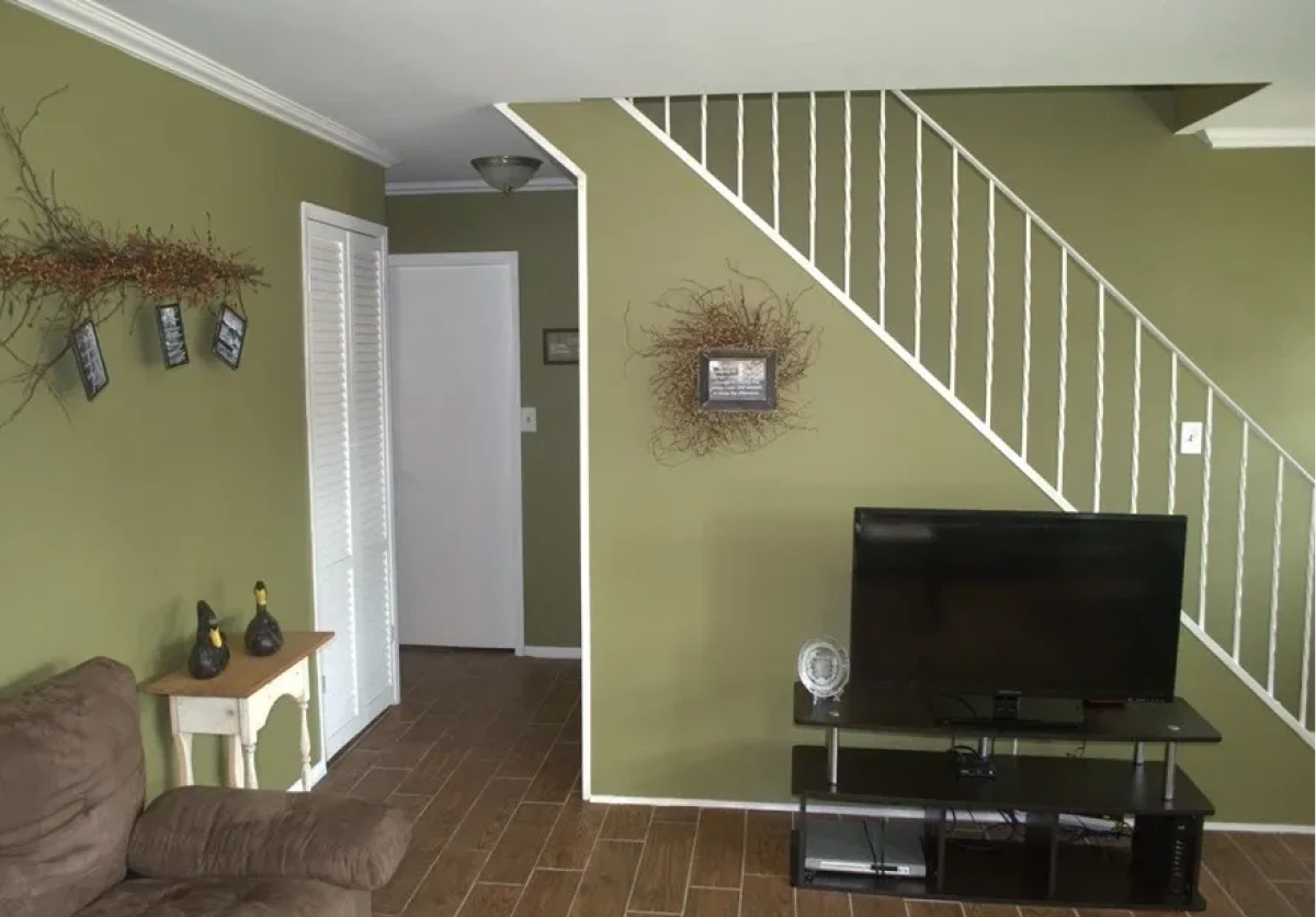 Living room with green walls and staircase.
