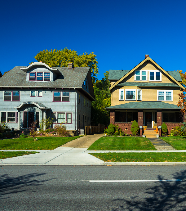 Two suburban houses under clear blue sky.